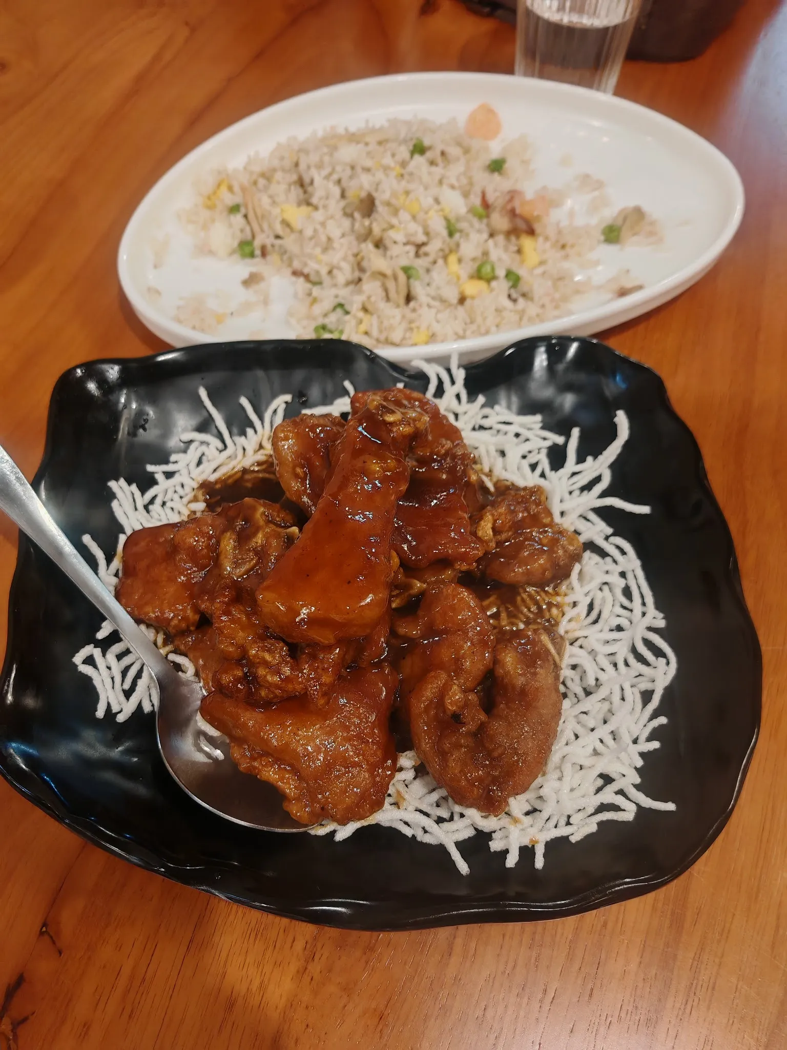 Braised pork ribs on crispy noodles in black plate